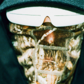 Man's face wearing glasses, black hood and mask